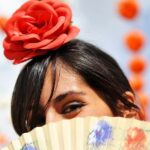 Girl at the feria looking over a fan