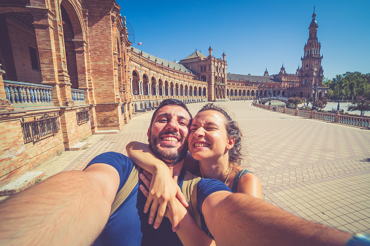 Couple taking a selfie ini the Plaza de España in Sevilla,