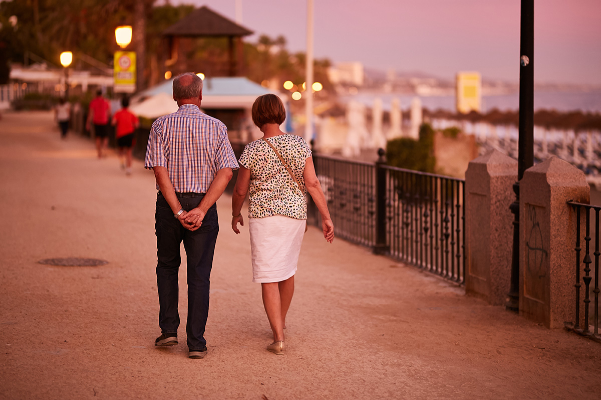 Couple strolling along the promenade at sunset.